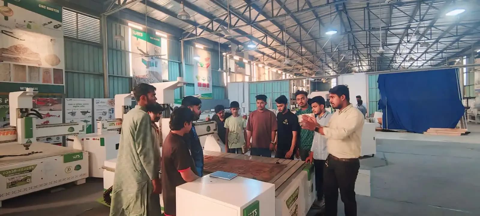 ওয়ার্কশপে CNC মেশিনের পাশে প্রশিক্ষক ও শিক্ষার্থীরা